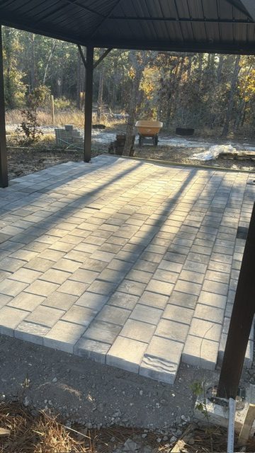 Covered paver patio finished behind a Tampa Bay home