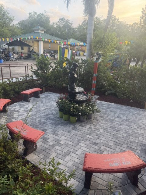 Paver patio with curved seating benches and planted borders