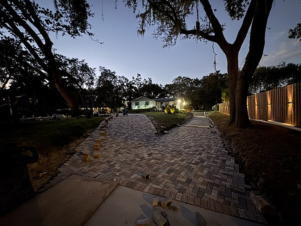 Paver walkway lit with low-voltage landscape lighting at dusk
