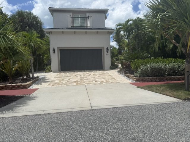 Modern Tampa home with a light paver driveway and clean landscape beds